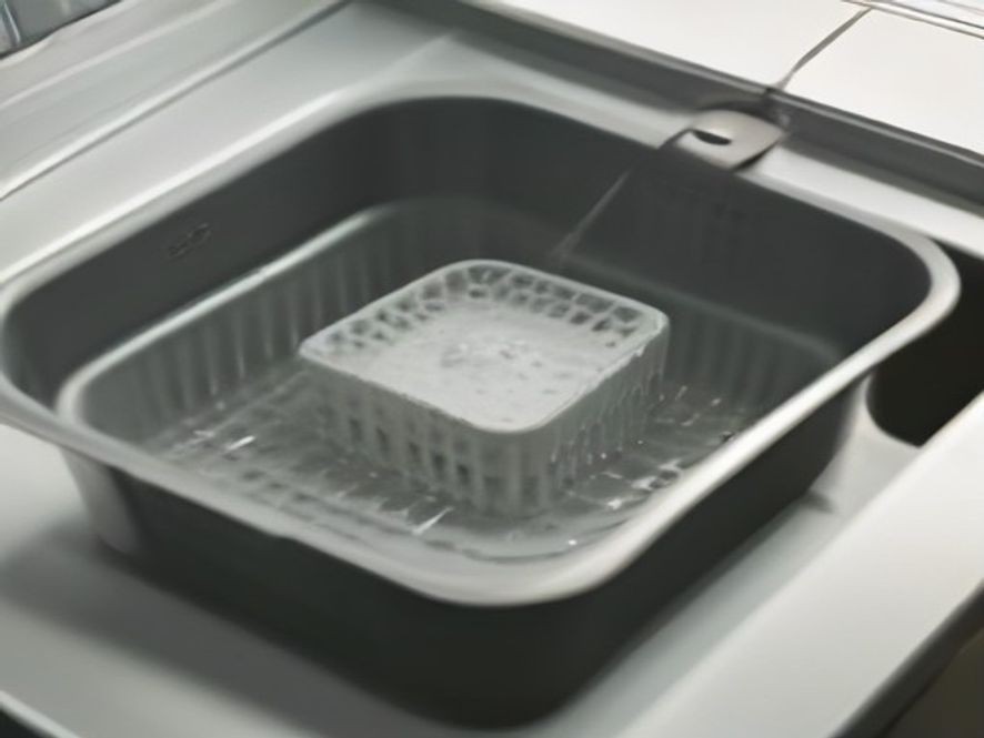 Soaking an air fryer basket to loosen stubborn baked-on grease