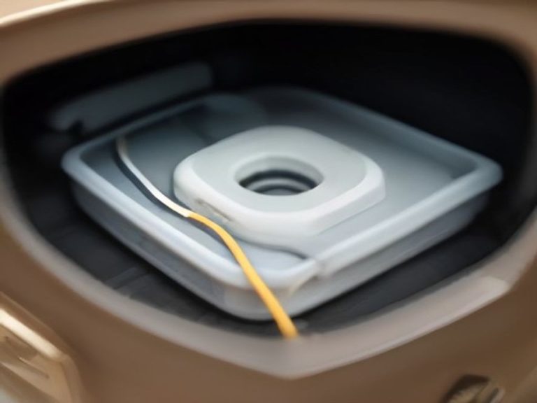 A power cable wrapped neatly around an adhesive organizer clip on an appliance.