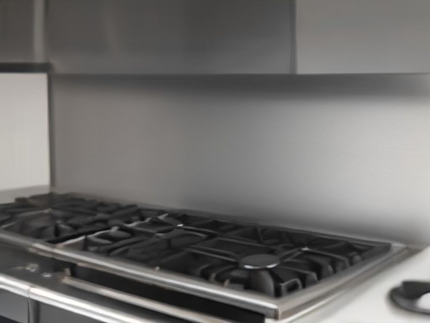 A spotless stainless steel stove backsplash reflecting warm kitchen lights.