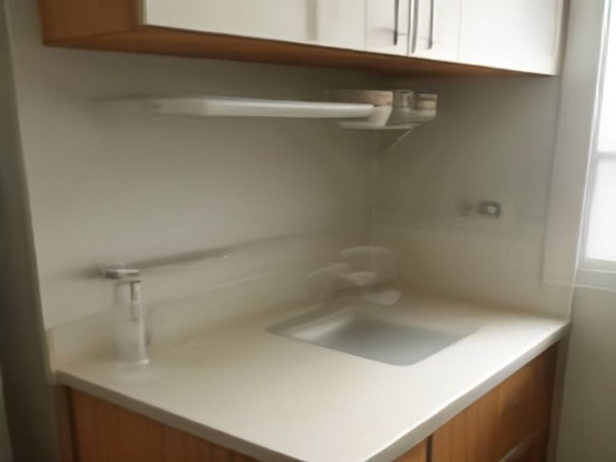 An over the sink cutting board expanding counter space in a tiny kitchen.