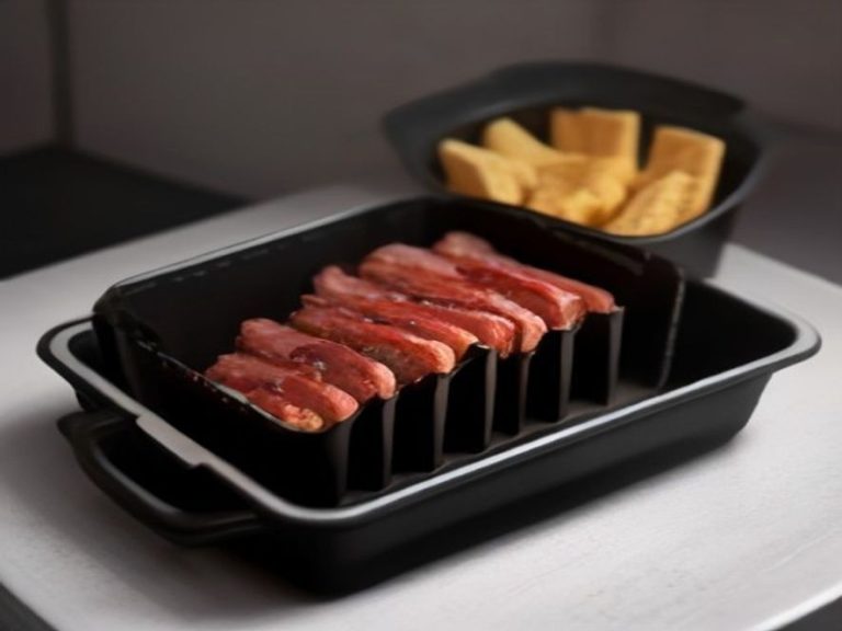 Thick bacon strips cooking over a grease tray inside a modern air fryer.