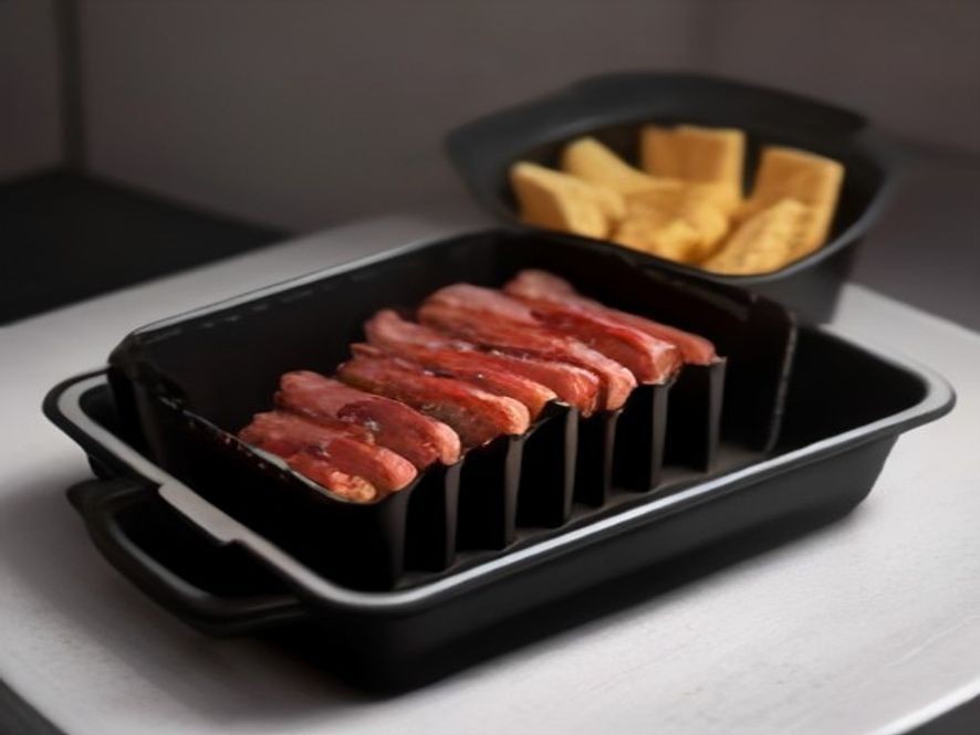 Thick bacon strips cooking over a grease tray inside a modern air fryer.