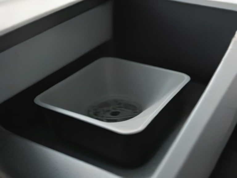 Garbage disposal unit mounted directly under a kitchen sink basin.