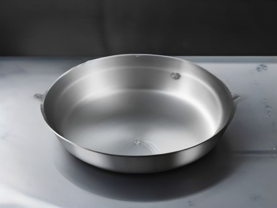 A spotless stainless steel skillet prepared on an induction stove.